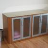Linen cabinet in Cherry with radius ends, aluminum framed milk glass doors and glass top