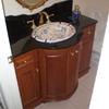 Custom radius door vanity in cherry with black granite top and custom cut backsplash